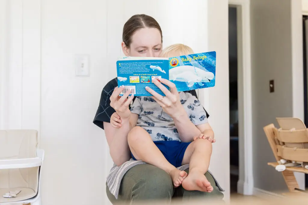 Mom reading her child the sing-along book "Baby Beluga"