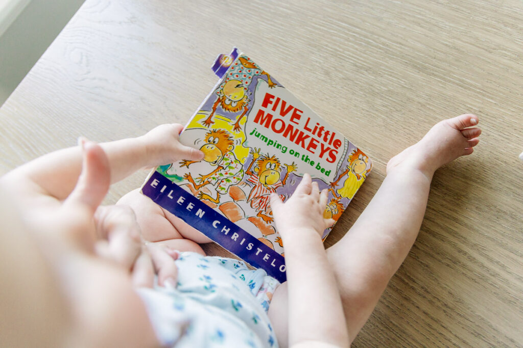 Child reading the sing-along book "Five Little Monkeys"