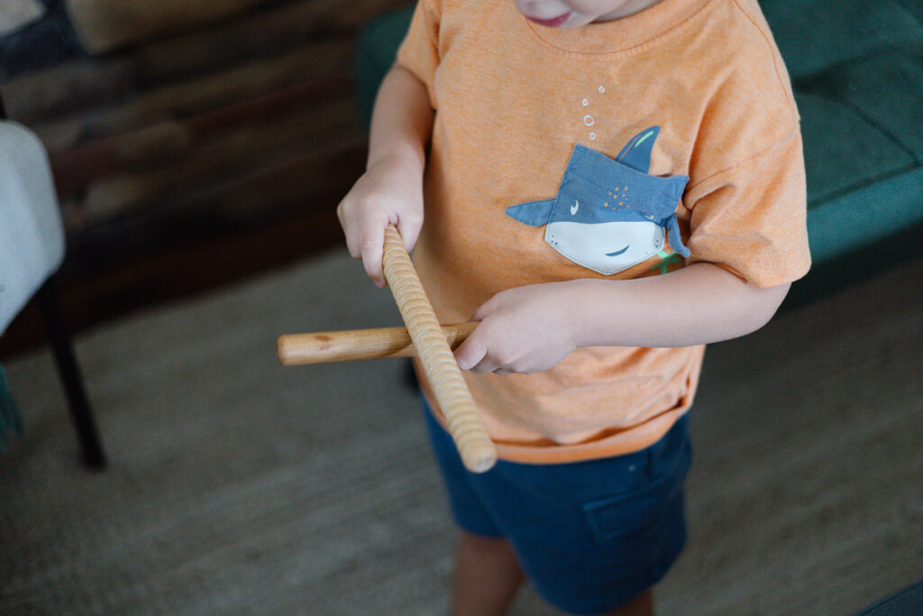 child rubbing rhythm sticks together