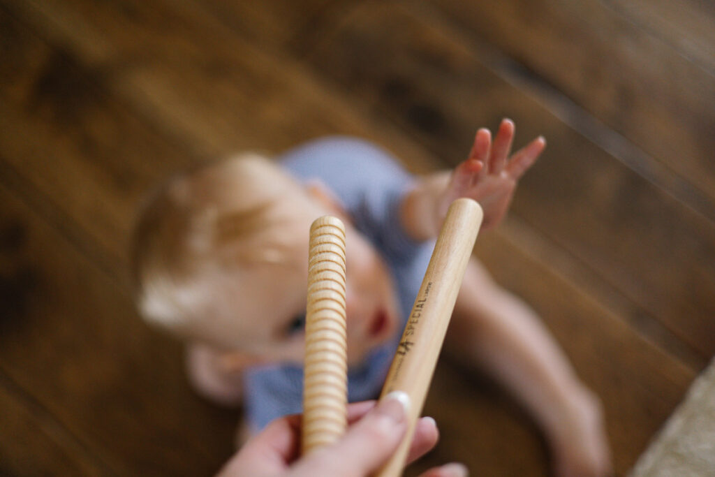 Baby reaching for rhythm sticks