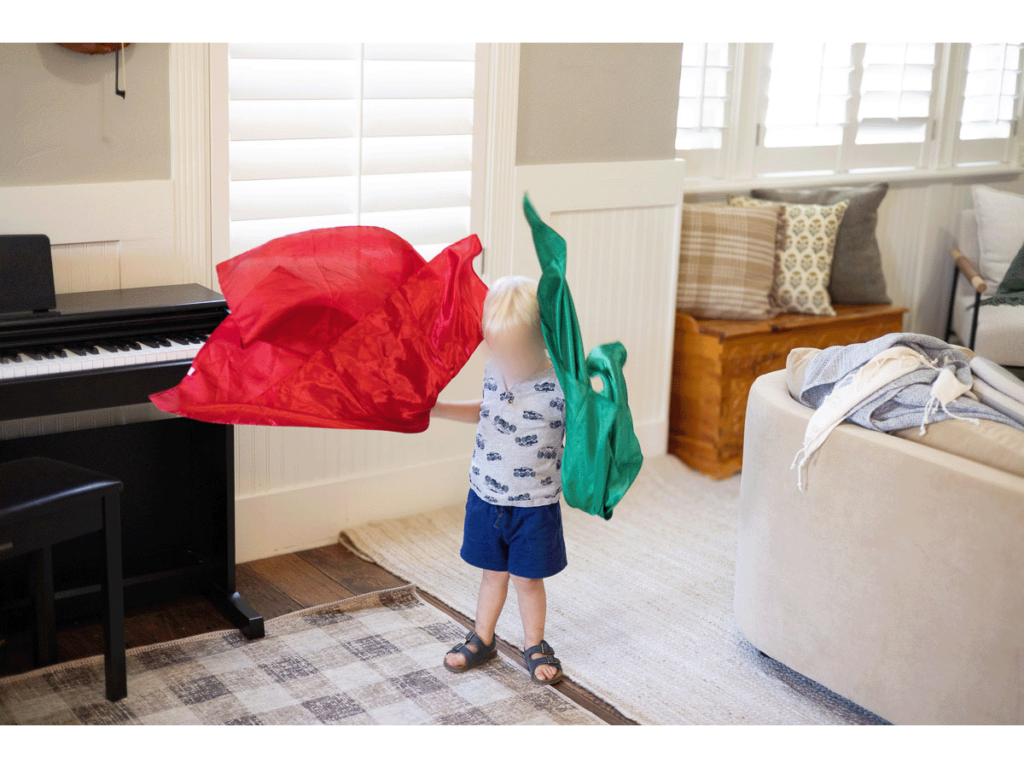 Child singing scarf song while waving a red and green scarf
