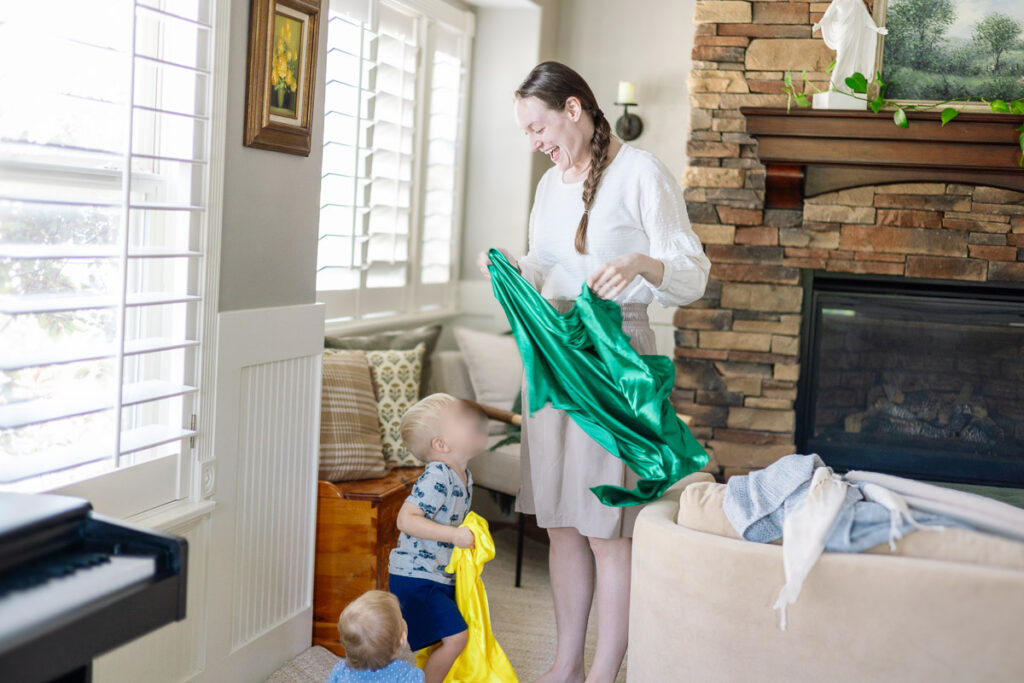 Mom holding a scarf and singing a song with her two kids