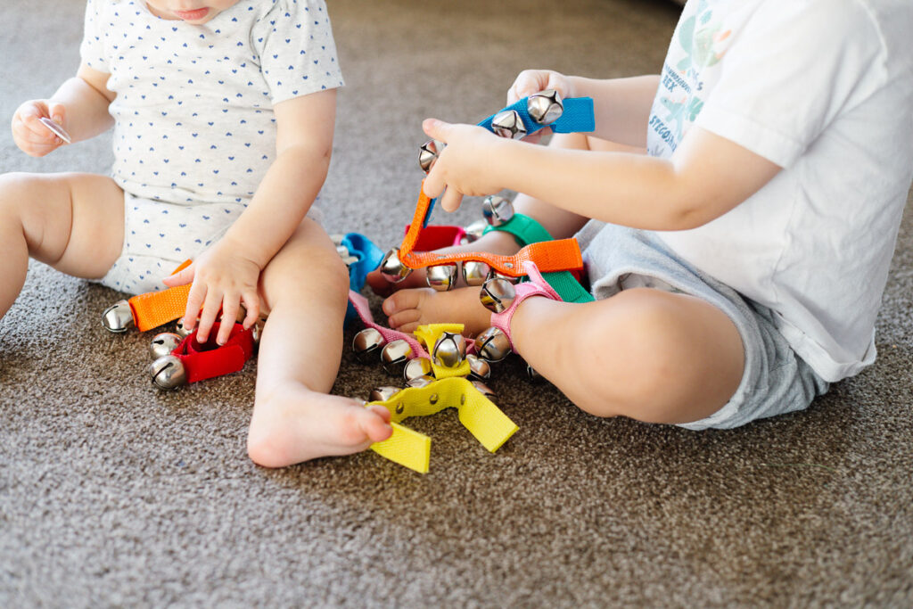 Two children sitting in a pile of bells